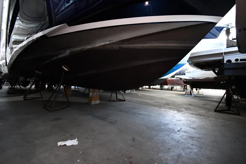 Slide: The Image of 2016 Tiara Yachts 50 Coupe in dry dock, showcasing hull and support stands. - 69