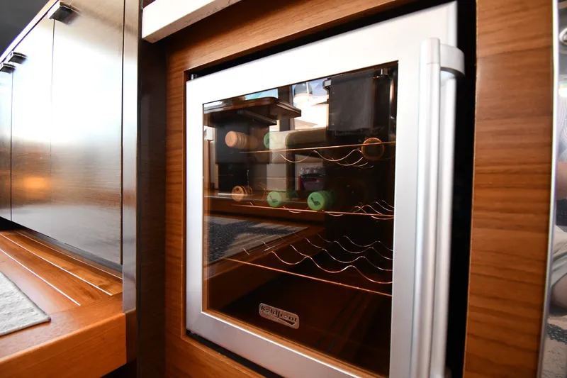 Slide: The Image of Wine cooler in 2016 Tiara Yachts 50 Coupe, featuring sleek wood cabinetry. - 50