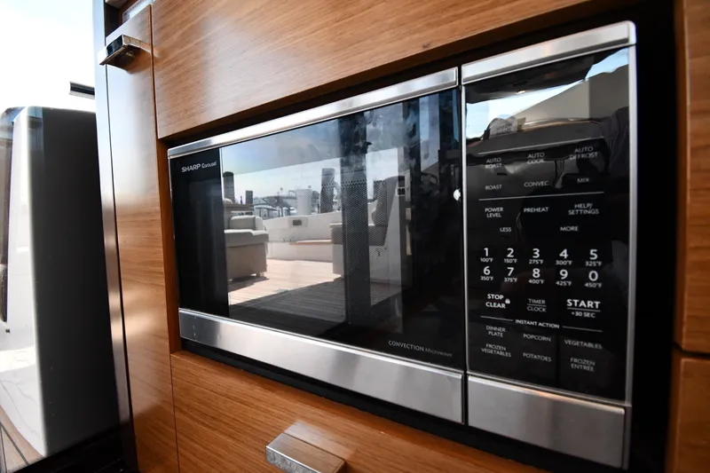 Slide: The Image of Built-in microwave on 2016 Tiara Yachts 50 Coupe, featuring sleek wood cabinetry. - 48