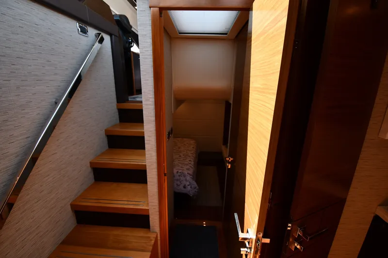 Slide: The Image of Interior view of 2016 Tiara Yachts 50 Coupe, featuring wooden stairs and cozy cabin. - 34