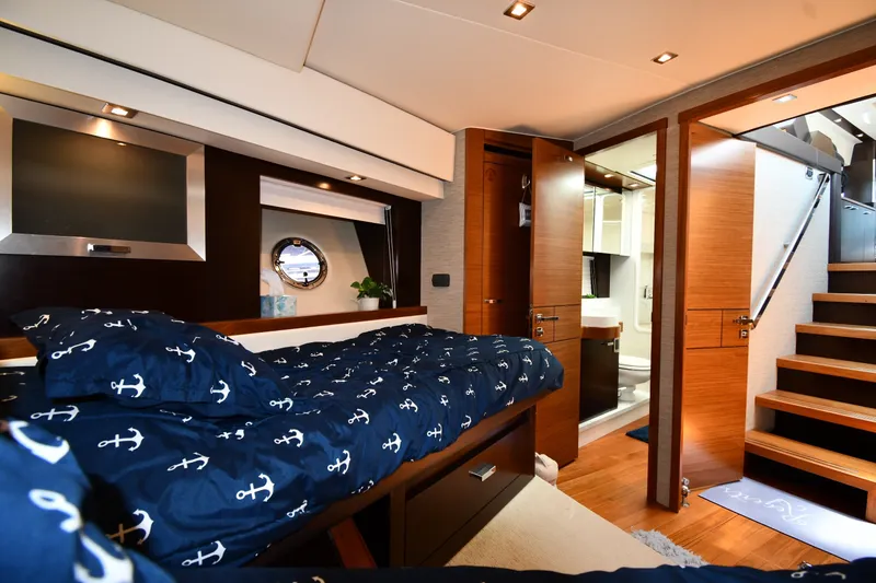 Slide: The Image of Luxurious 2016 Tiara Yachts 50 Coupe interior with nautical-themed bedding and modern wood finishes. - 28