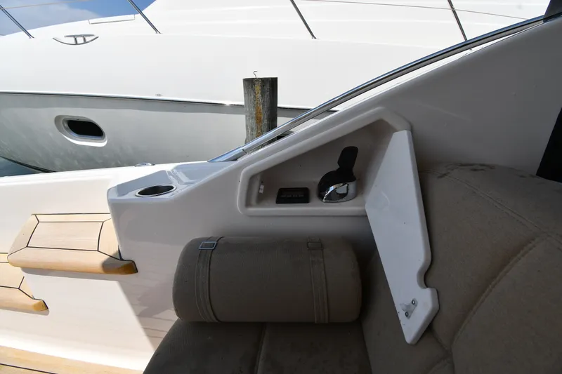 Slide: The Image of Interior view of a 2016 Tiara Yachts 50 Coupe, showcasing seating and control panel. - 14