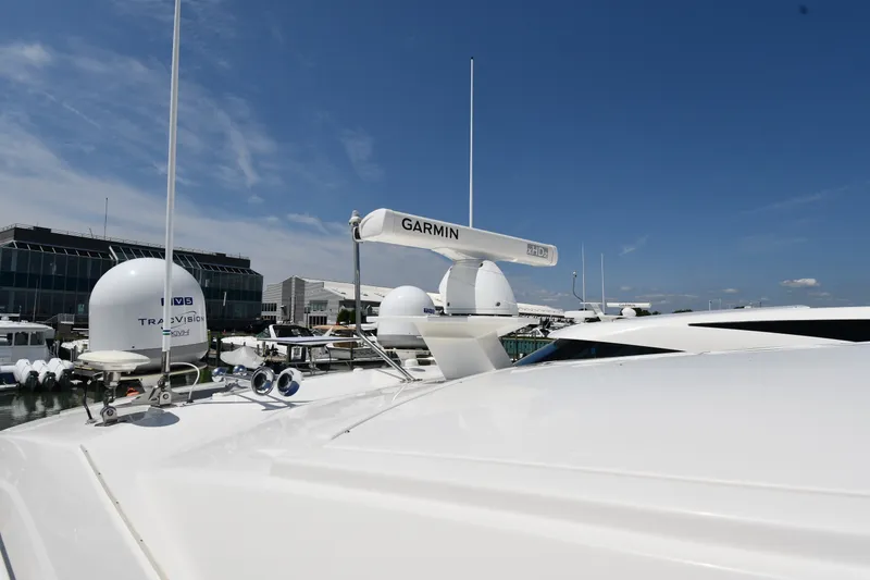 Slide: The Image of 2016 Tiara Yachts 50 Coupe with Garmin radar and TracVision satellite, docked under clear sky. - 9