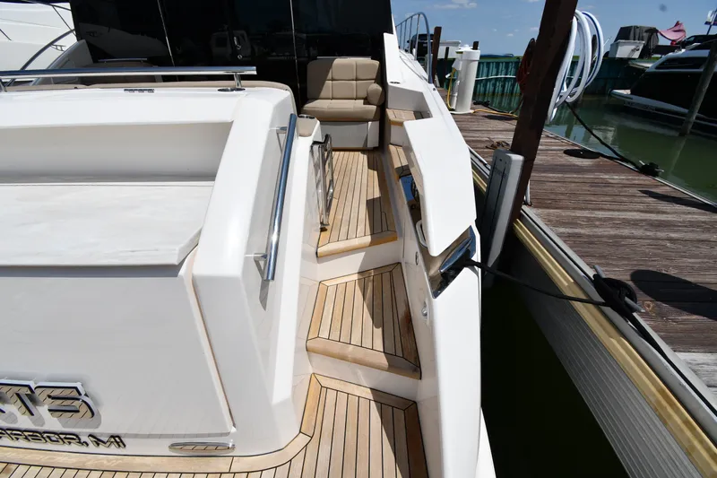 Slide: The Image of 2016 Tiara Yachts 50 Coupe docked, showcasing sleek deck design and luxurious seating. - 15