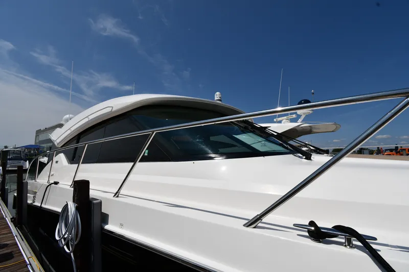Slide: The Image of 2016 Tiara Yachts 50 Coupe docked under clear blue sky. - 2