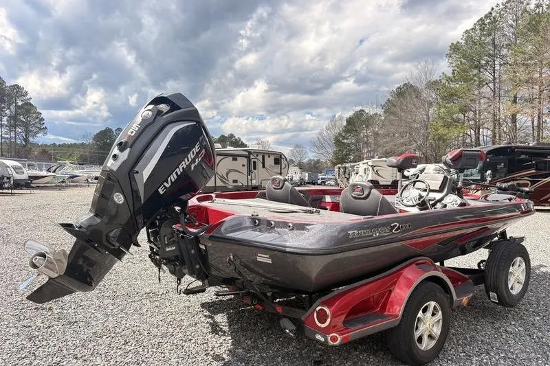 Slide: The Image of 2017 Ranger Z518 Comanche boat with Evinrude motor on trailer, parked outdoors. - 2