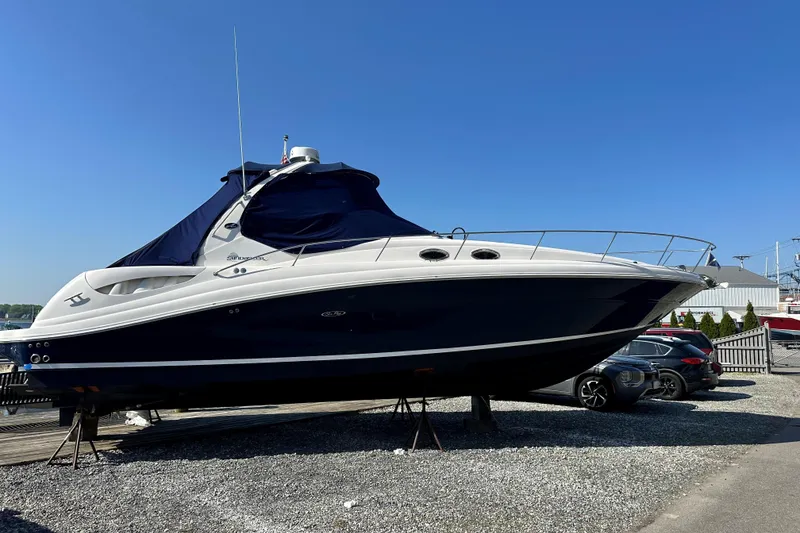 The Image of 2006 Sea Ray 340 Sundancer boat on display, blue and white exterior, sunny day. - 1