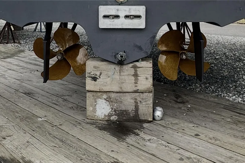 Slide: The Image of Propellers of a 2006 Sea Ray 340 Sundancer on wooden blocks, displayed outdoors. - 13