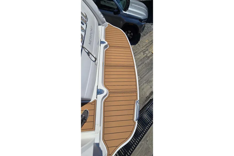 Slide: The Image of 2006 Sea Ray 340 Sundancer swim platform with teak decking, docked beside a vehicle. - 15