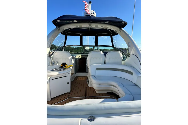 Slide: The Image of 2006 Sea Ray 340 Sundancer boat interior with white seating and wooden flooring. - 16