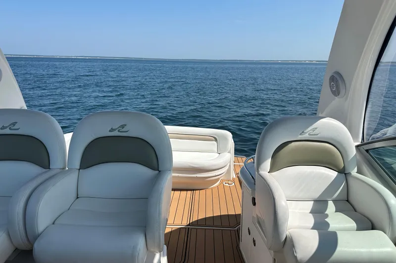 Slide: The Image of 2006 Sea Ray 340 Sundancer yacht interior with white seating, overlooking calm ocean waters. - 19