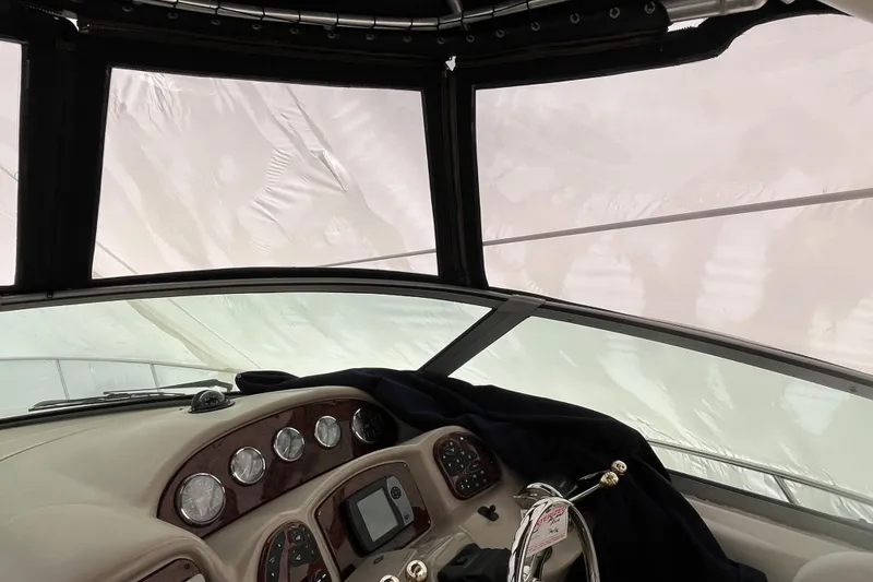 Slide: The Image of Interior view of 2006 Sea Ray 340 Sundancer boat cockpit with covered windows. - 23