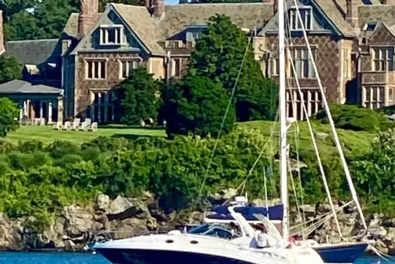 Slide: The Image of Sea Ray 340 Sundancer yacht cruising near a grand estate, lush greenery, 2006 model. - 3