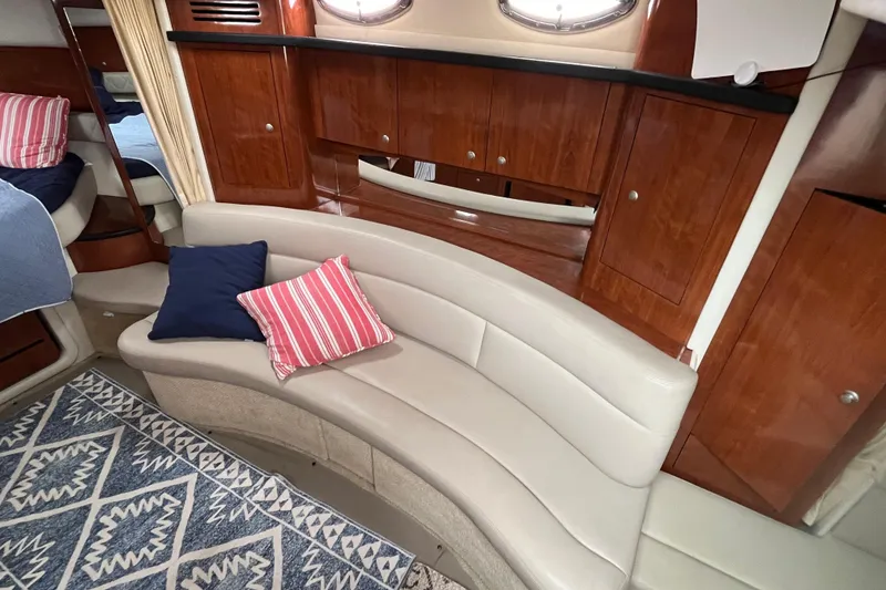 Slide: The Image of Interior of 2006 Sea Ray 340 Sundancer with curved seating and wooden cabinetry. - 32