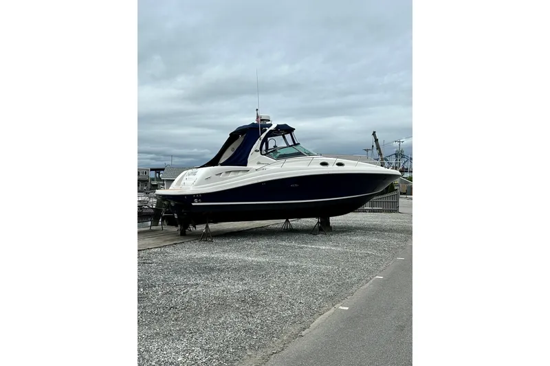 Slide: The Image of 2006 Sea Ray 340 Sundancer boat on dry dock, overcast sky background. - 5