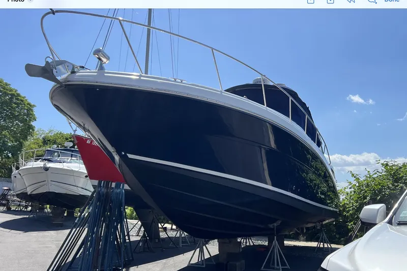 Slide: The Image of 2006 Sea Ray 340 Sundancer boat on stands, blue hull, sunny day. - 6