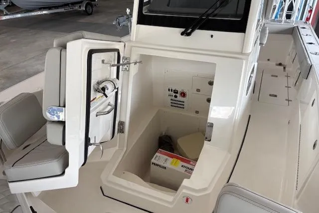 Slide: The Image of 2026 Pursuit S 248 Sport boat interior with open storage compartment and seating. - 9