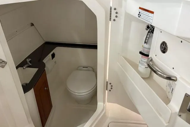 Slide: The Image of Interior of 2026 Pursuit DC 266 Dual Console boat bathroom with sink and toilet. - 12