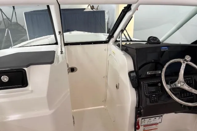 Slide: The Image of 2026 Pursuit DC 266 Dual Console boat interior with steering wheel and dashboard. - 13