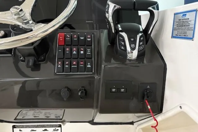 Slide: The Image of Control panel of 2026 Pursuit DC 266 Dual Console boat with steering wheel and throttle. - 14