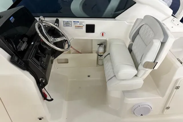 Slide: The Image of 2026 Pursuit DC 266 Dual Console boat cockpit with steering wheel and white seating. - 17