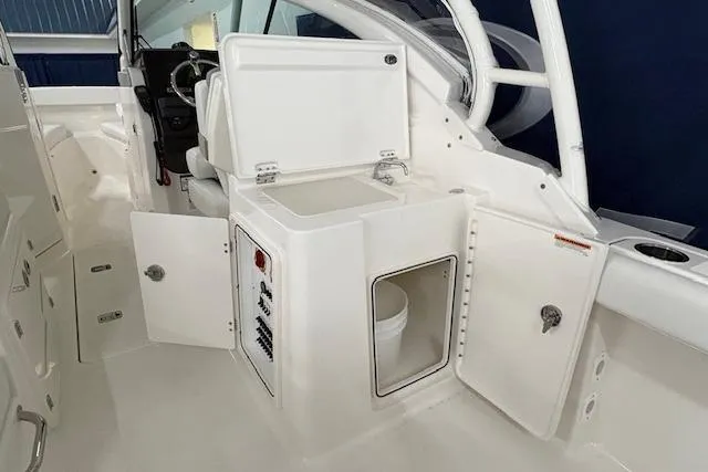 Slide: The Image of 2026 Pursuit DC 266 Dual Console interior with open storage compartments. - 6