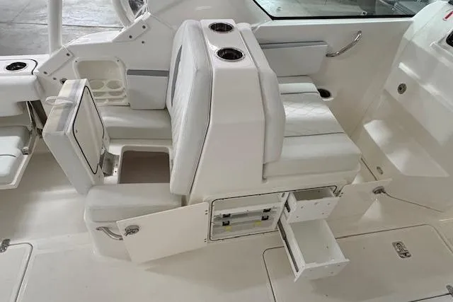 Slide: The Image of 2026 Pursuit DC 266 Dual Console boat interior with white seating and storage compartments. - 7