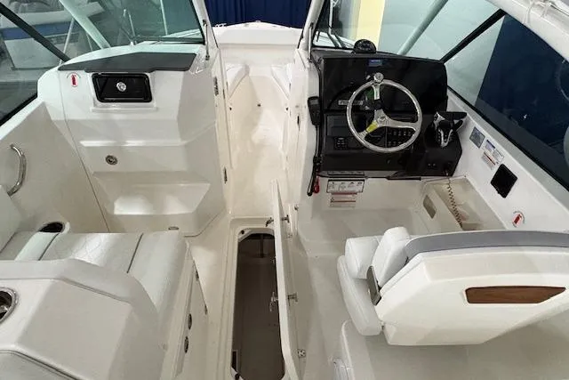 Slide: The Image of 2026 Pursuit DC 266 Dual Console boat interior with steering wheel and seating. - 8