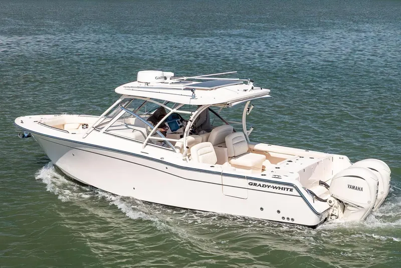 The Image of 2024 Grady-White Freedom 307 boat cruising on a serene lake with Yamaha engines. - 0