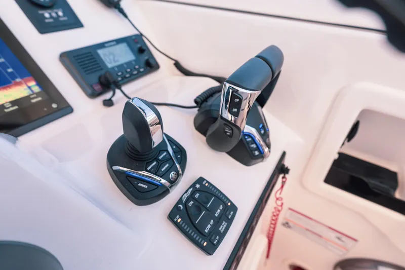 Slide: The Image of Control panel of 2024 Grady-White Freedom 307 boat with joystick and throttle controls. - 11