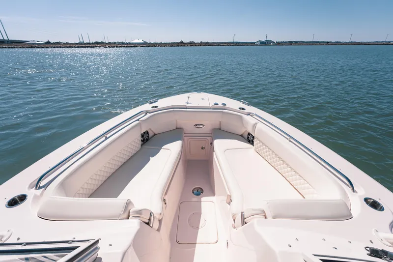 Slide: The Image of 2024 Grady-White Freedom 307 boat interior with spacious seating on calm water. - 17