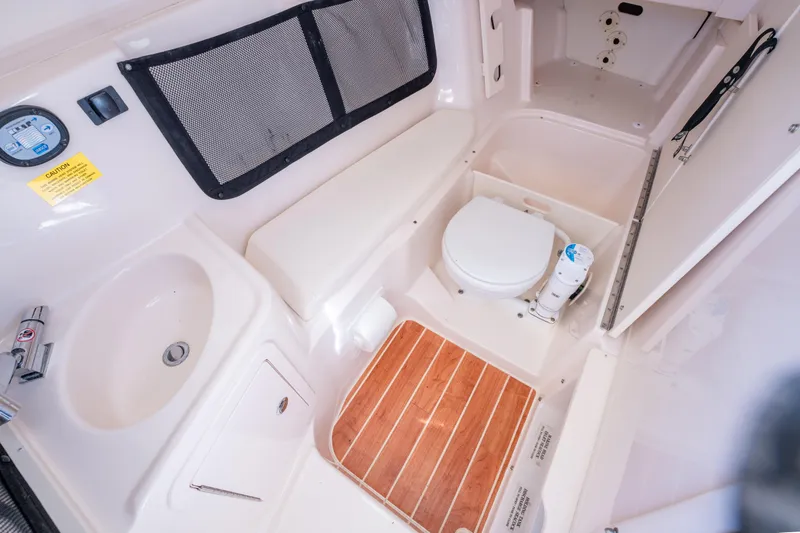 Slide: The Image of 2024 Grady-White Freedom 307 boat interior with sink, toilet, and wooden floor. - 26