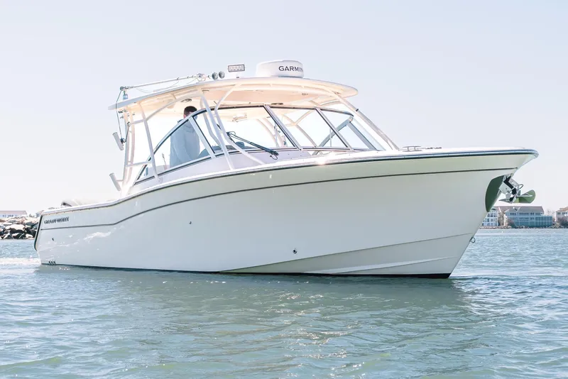 Slide: The Image of 2024 Grady-White Freedom 307 boat on calm water under clear sky. - 4