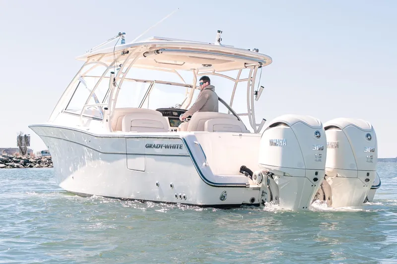 Slide: The Image of 2024 Grady-White Freedom 307 boat cruising on open water with twin Yamaha engines. - 5