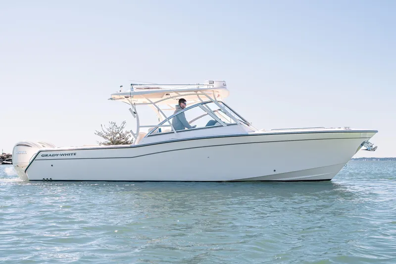 Slide: The Image of 2024 Grady-White Freedom 307 boat cruising on calm water under clear sky. - 7