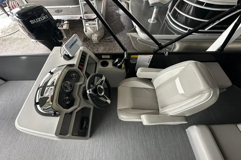 Slide: The Image of 2026 Sweetwater 2286FX boat helm with steering wheel, gauges, and comfortable captain's chair. - 13