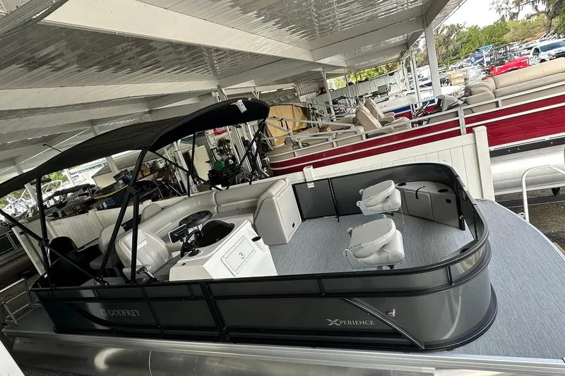 Slide: The Image of 2026 Sweetwater 2286FX pontoon boat with canopy, docked in a covered marina. - 2