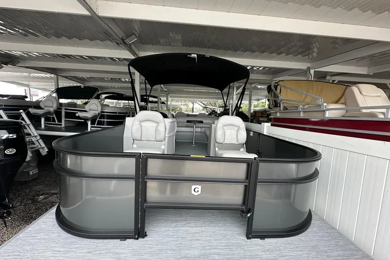 Slide: The Image of 2026 Sweetwater 2286FX pontoon boat with canopy in a covered showroom. - 3
