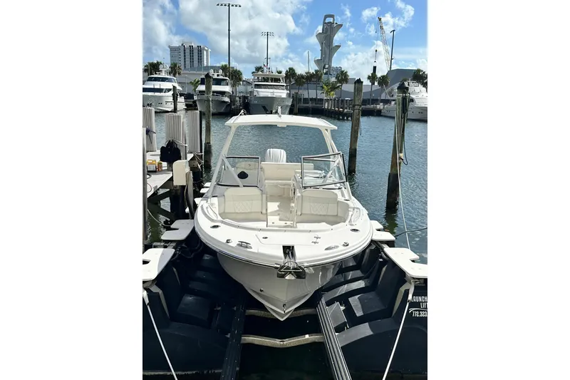 Slide: The Image of 2023 Edgewater 248CX Crossover boat docked at marina under clear sky. - 11