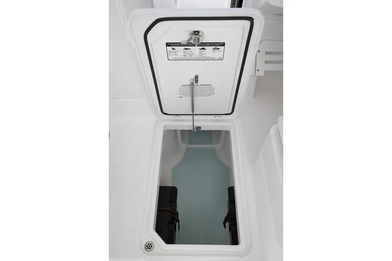 Slide: The Image of Manufacturer Provided Image: 2023 Edgewater 248CX Crossover boat storage compartment, open hatch, white interior. - 8