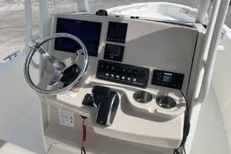 Slide: The Image of 2024 Boston Whaler 220 Dauntless boat dashboard with steering wheel and control panel. - 11