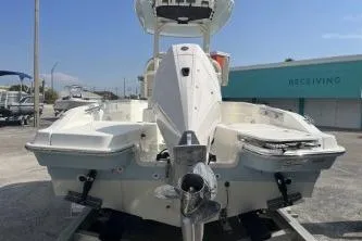 Slide: The Image of 2024 Boston Whaler 220 Dauntless boat, rear view, in a marina setting. - 6