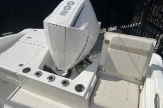 Slide: The Image of 2024 Boston Whaler 220 Dauntless boat with Mercury engine, featuring sleek seating and rod holders. - 7