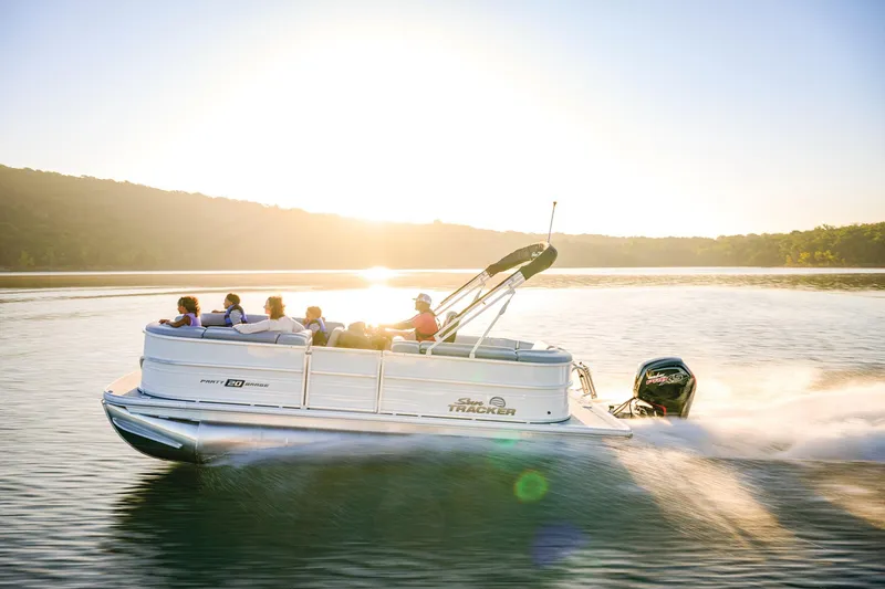 The Image of 2026 Sun Tracker Party Barge 20 DLX pontoon boat on trailer, parked outdoors. - 0