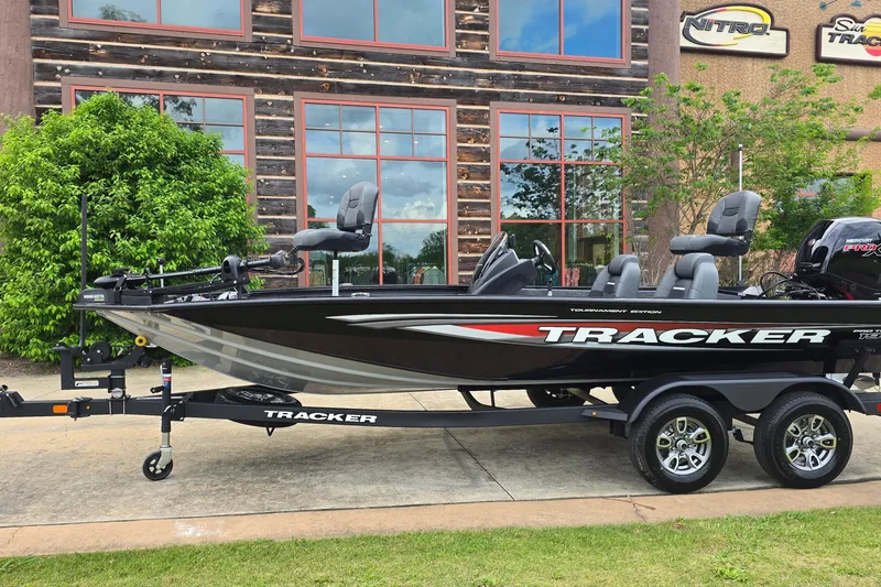 The Image of 2026 Tracker Pro Team 195 boat on trailer, parked outside a building. - 0