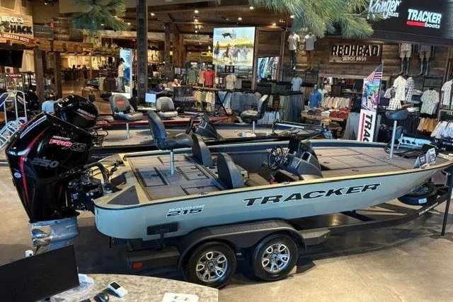 The Image of 2026 Tracker Savage 215 boat displayed in a showroom with fishing gear. - 0