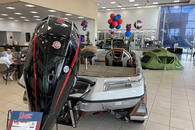 Slide: The Image of 2026 Ranger Z520R Cup-Equipped boat displayed in showroom with balloons and camping gear. - 2
