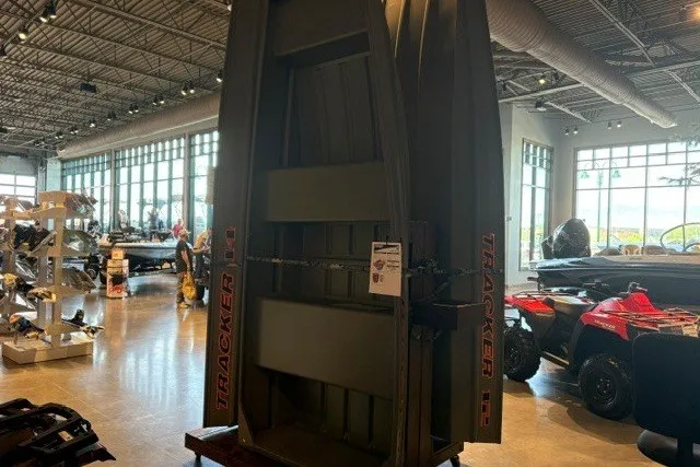 The Image of 2026 Tracker Grizzly 10 Jon boat displayed in a showroom with other vehicles. - 0