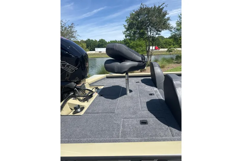 Slide: The Image of 2026 Tracker Pro Team 190 boat deck with seating, near a serene lake. - 6
