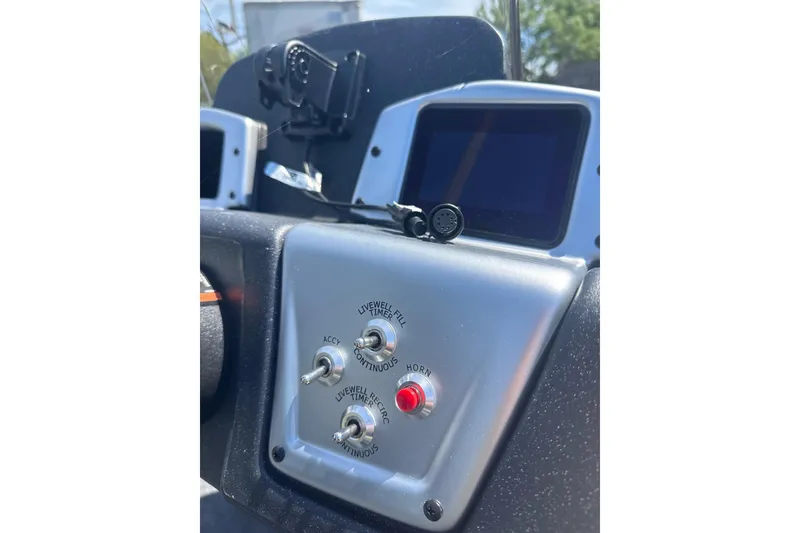 Slide: The Image of Dashboard controls of 2026 Tracker Pro Team 190 boat with switches and screens. - 8